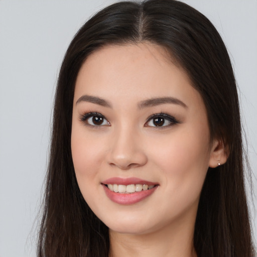 Joyful asian young-adult female with long  brown hair and brown eyes
