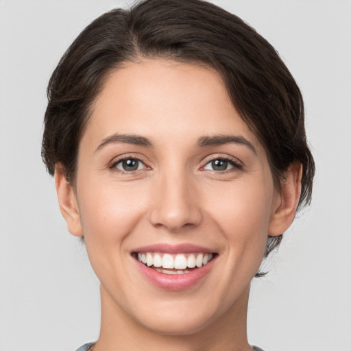 Joyful white young-adult female with short  brown hair and brown eyes