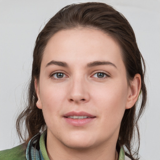 Joyful white young-adult female with medium  brown hair and grey eyes