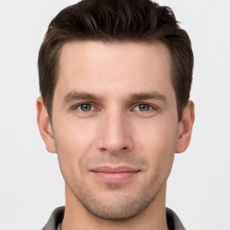 Joyful white young-adult male with short  brown hair and grey eyes