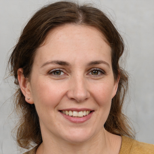 Joyful white adult female with medium  brown hair and grey eyes