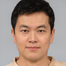 Joyful asian young-adult male with short  brown hair and brown eyes