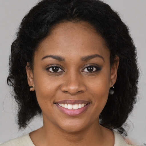 Joyful black young-adult female with medium  brown hair and brown eyes