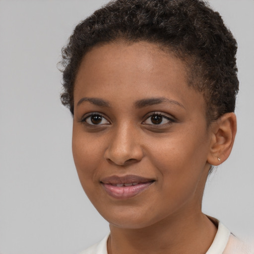 Joyful black young-adult female with short  brown hair and brown eyes