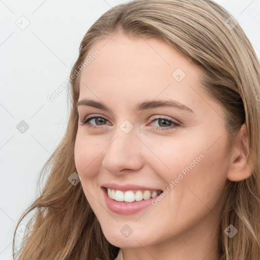 Joyful white young-adult female with long  brown hair and blue eyes