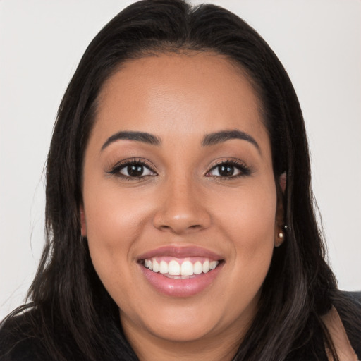 Joyful latino young-adult female with long  brown hair and brown eyes