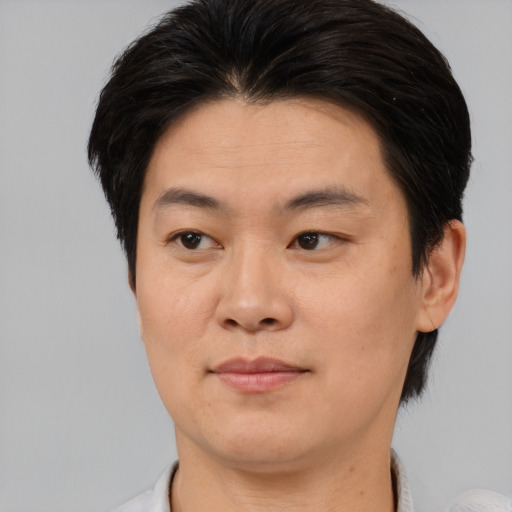 Joyful asian young-adult male with short  brown hair and brown eyes