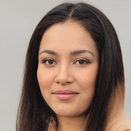 Joyful latino young-adult female with long  brown hair and brown eyes