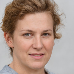 Joyful white adult female with medium  brown hair and blue eyes