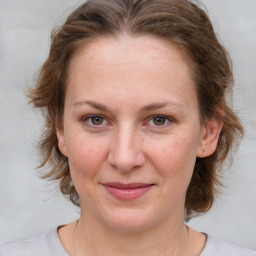 Joyful white young-adult female with medium  brown hair and blue eyes