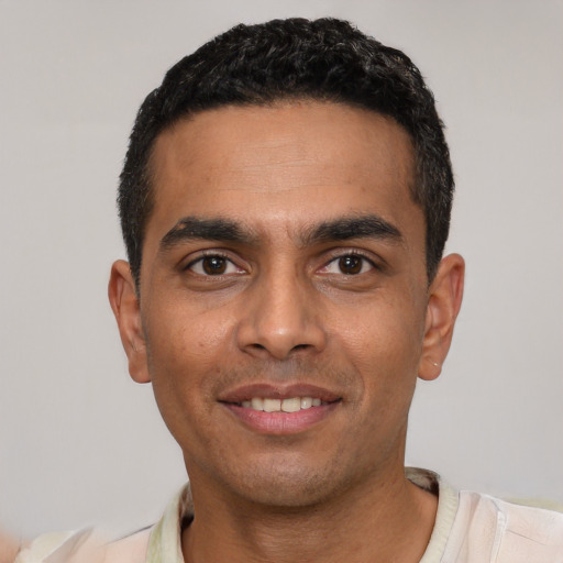 Joyful latino young-adult male with short  black hair and brown eyes