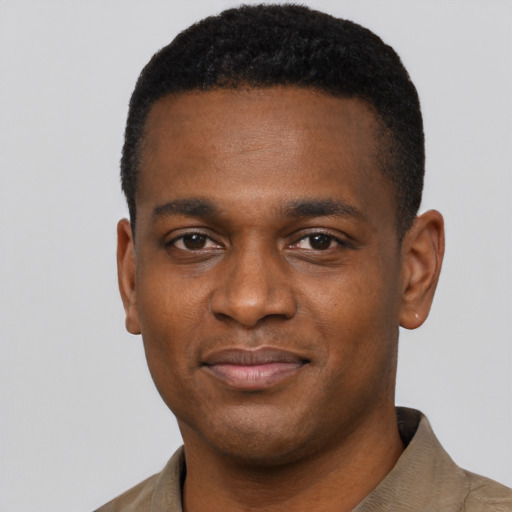 Joyful black young-adult male with short  black hair and brown eyes