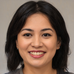 Joyful asian young-adult female with medium  brown hair and brown eyes