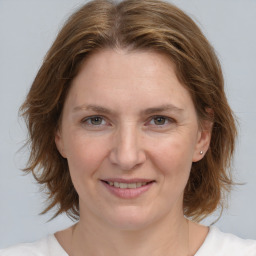 Joyful white young-adult female with medium  brown hair and blue eyes