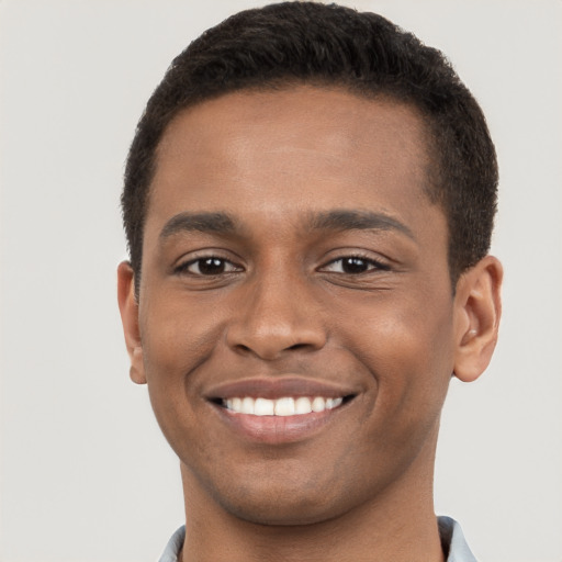 Joyful black young-adult male with short  brown hair and brown eyes