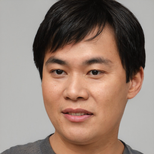 Joyful asian young-adult male with short  black hair and brown eyes