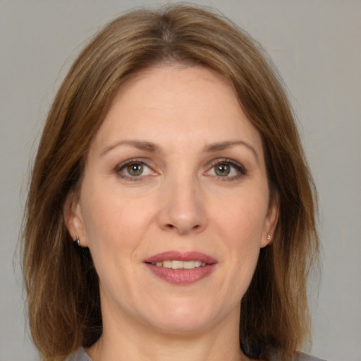 Joyful white adult female with medium  brown hair and grey eyes