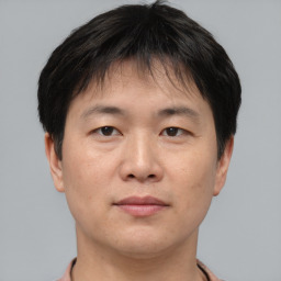 Joyful asian adult male with short  brown hair and brown eyes