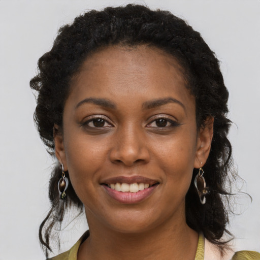 Joyful black young-adult female with long  brown hair and brown eyes