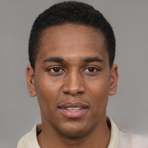 Joyful black young-adult male with short  brown hair and brown eyes