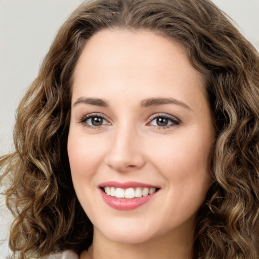 Joyful white young-adult female with long  brown hair and green eyes