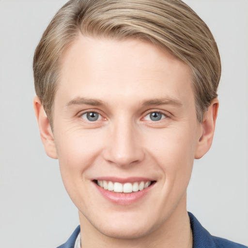 Joyful white young-adult male with short  brown hair and grey eyes