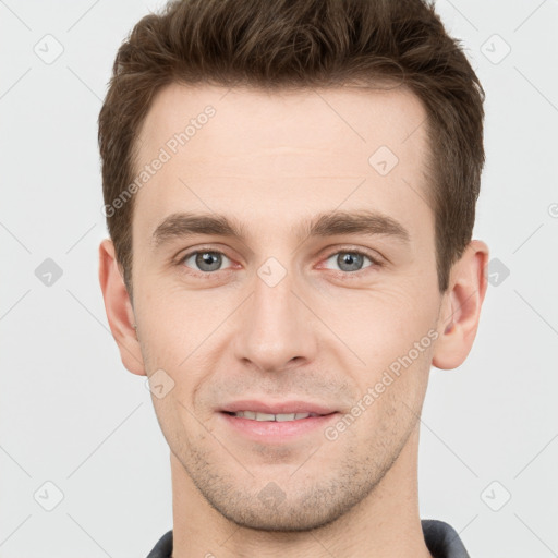 Joyful white young-adult male with short  brown hair and grey eyes