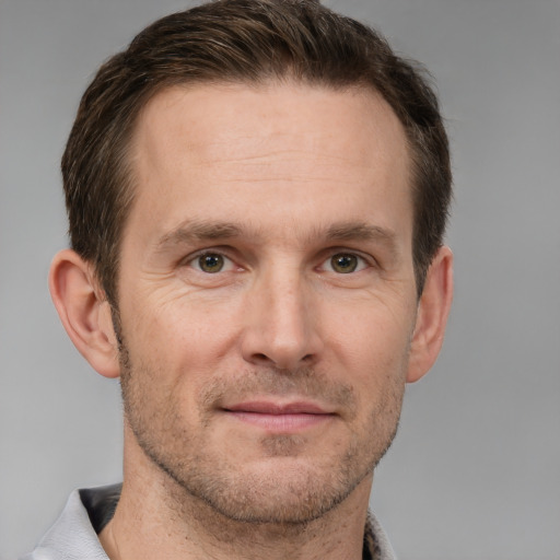 Joyful white adult male with short  brown hair and grey eyes