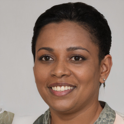 Joyful black young-adult female with short  black hair and brown eyes