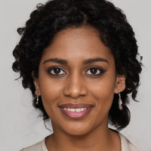 Joyful black young-adult female with long  black hair and brown eyes