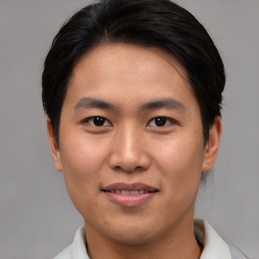 Joyful asian young-adult male with short  brown hair and brown eyes