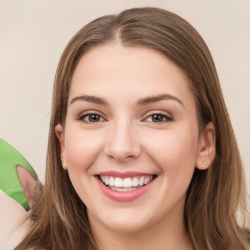 Joyful white young-adult female with long  brown hair and brown eyes