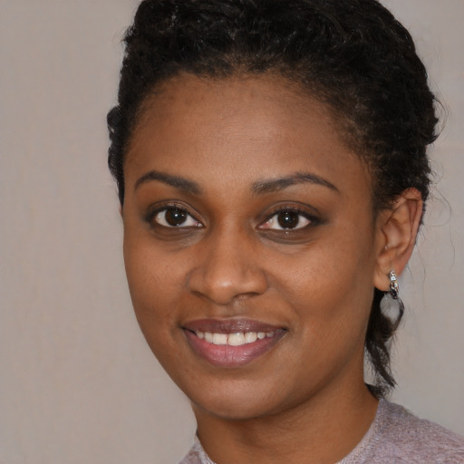 Joyful black young-adult female with short  brown hair and brown eyes