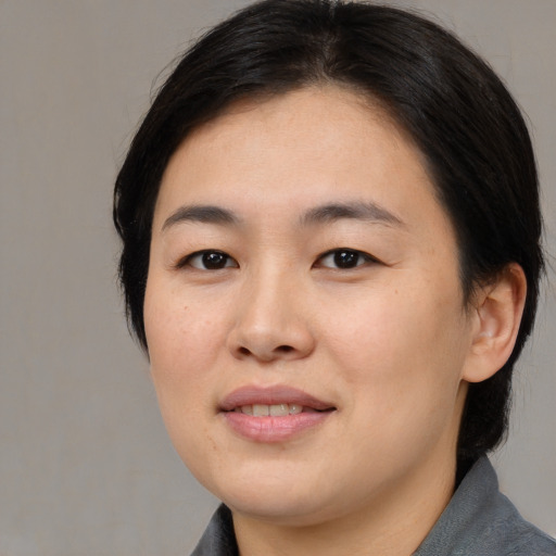 Joyful asian young-adult female with medium  brown hair and brown eyes