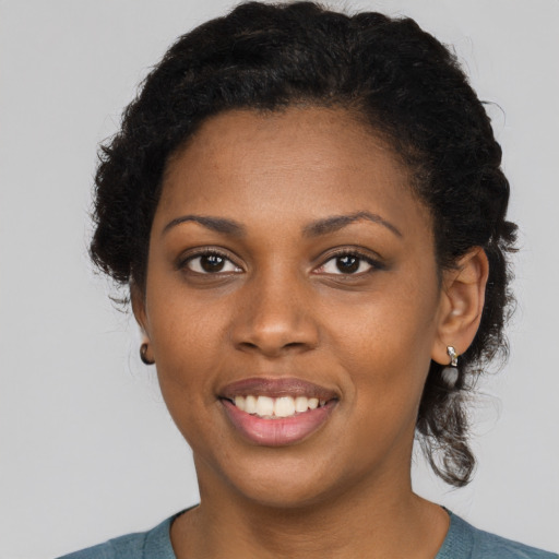 Joyful black young-adult female with short  black hair and brown eyes