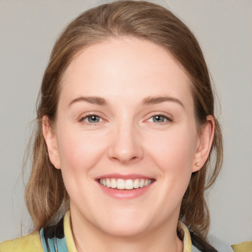 Joyful white young-adult female with medium  brown hair and blue eyes