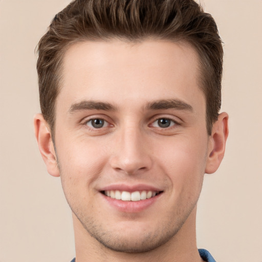 Joyful white young-adult male with short  brown hair and grey eyes