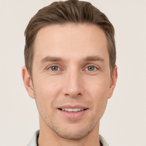 Joyful white young-adult male with short  brown hair and grey eyes