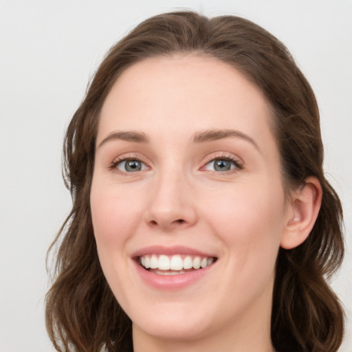 Joyful white young-adult female with long  brown hair and green eyes