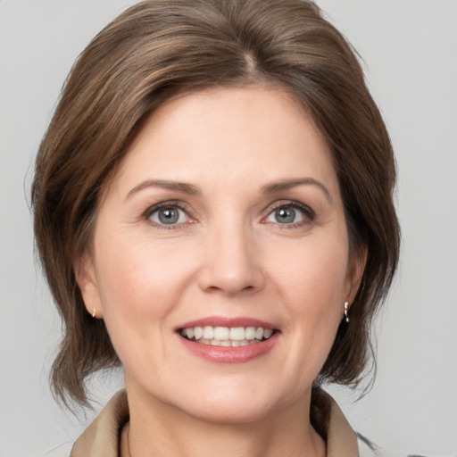 Joyful white young-adult female with medium  brown hair and grey eyes