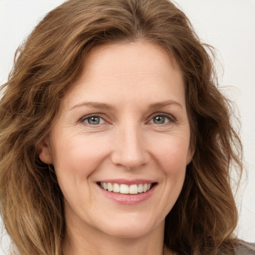 Joyful white adult female with long  brown hair and brown eyes