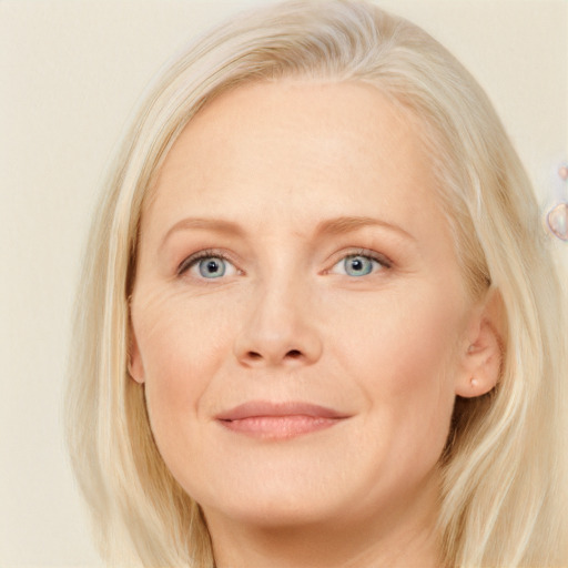 Joyful white adult female with long  blond hair and blue eyes