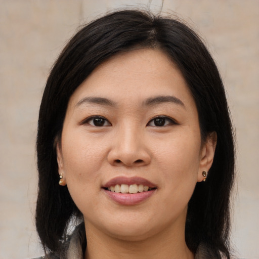Joyful asian young-adult female with medium  brown hair and brown eyes