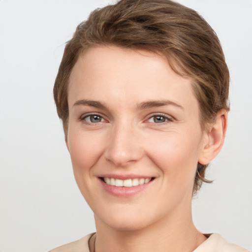 Joyful white young-adult female with short  brown hair and grey eyes