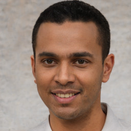 Joyful latino young-adult male with short  black hair and brown eyes