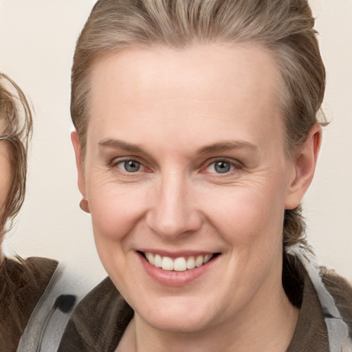 Joyful white adult female with medium  brown hair and grey eyes