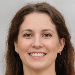 Joyful white adult female with long  brown hair and grey eyes