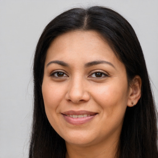 Joyful latino adult female with long  brown hair and brown eyes