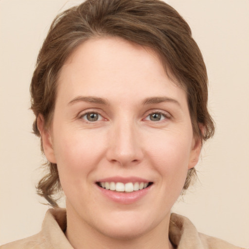 Joyful white young-adult female with medium  brown hair and green eyes