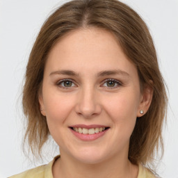 Joyful white young-adult female with medium  brown hair and grey eyes